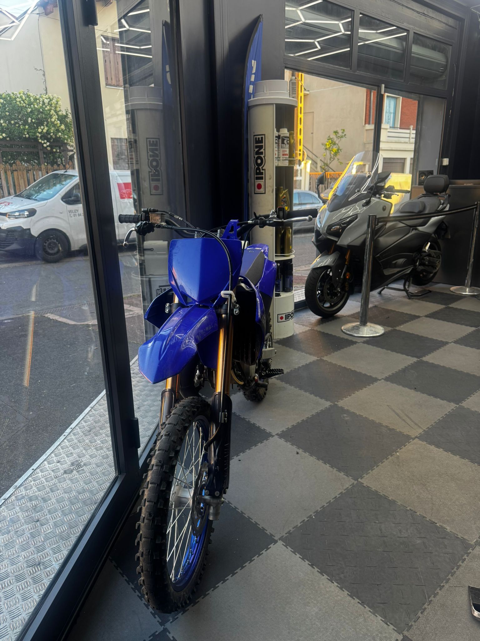 Yamaha WR bleue à l'entrée du garage